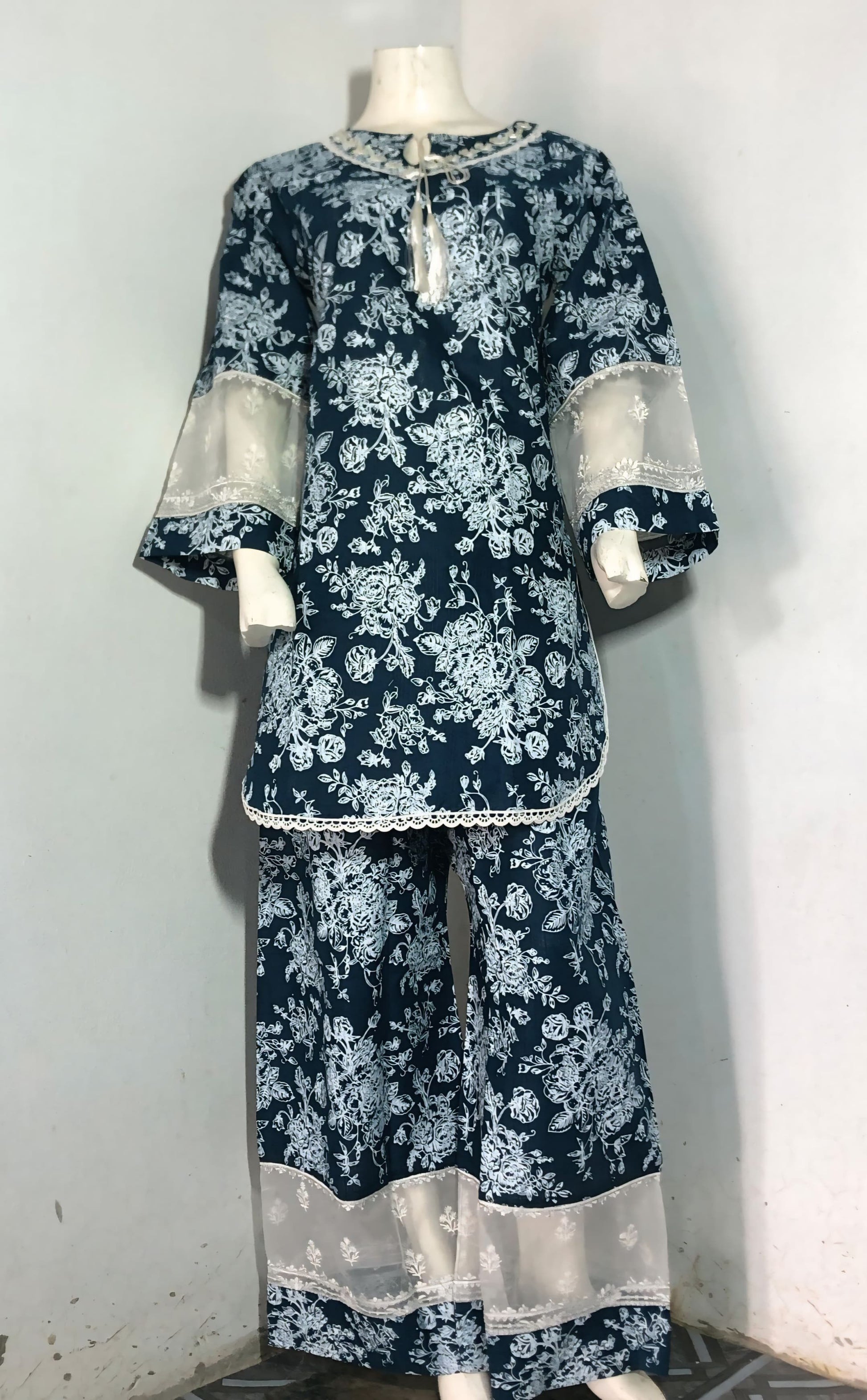 Navy floral outfit with white accents on a mannequin against a white background